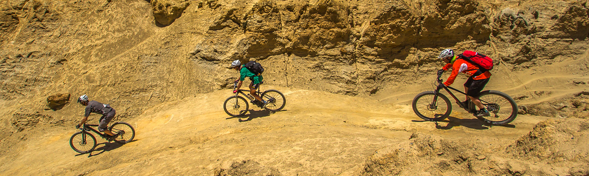 3 mountain bikers che pedalano in un mondo minerale