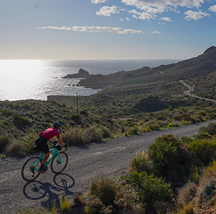 Ciclista gravel su una pista vicino al mare in Andalusia